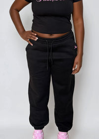 Thumbnail for Woman wearing a black jogger pants 'Pink Seal' branding with puff printing. 100% cotton fleece.