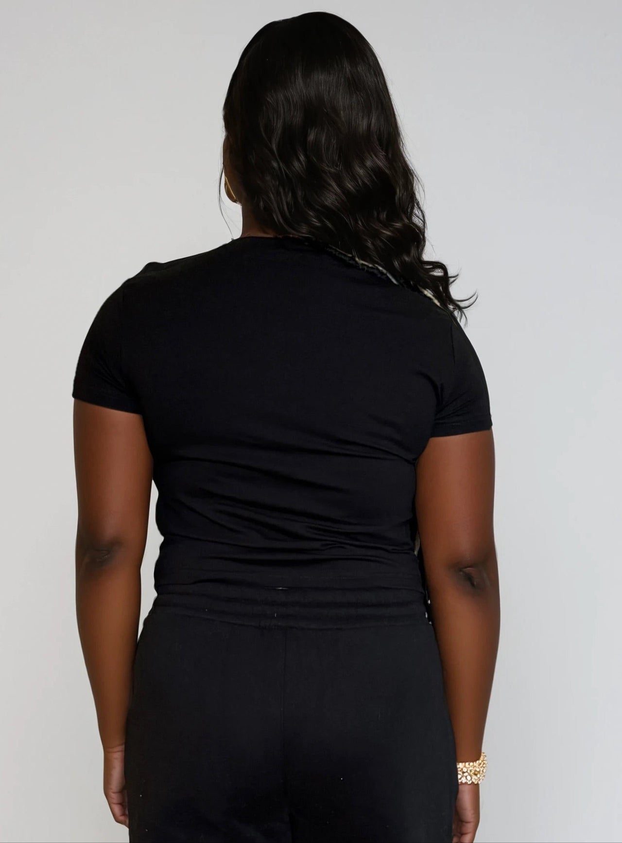 Woman wearing a black crop top with 'Pink Seal' branding with puff printing.