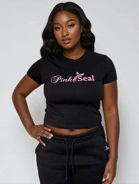 Thumbnail for Woman wearing a black crop top with 'Pink Seal' branding.