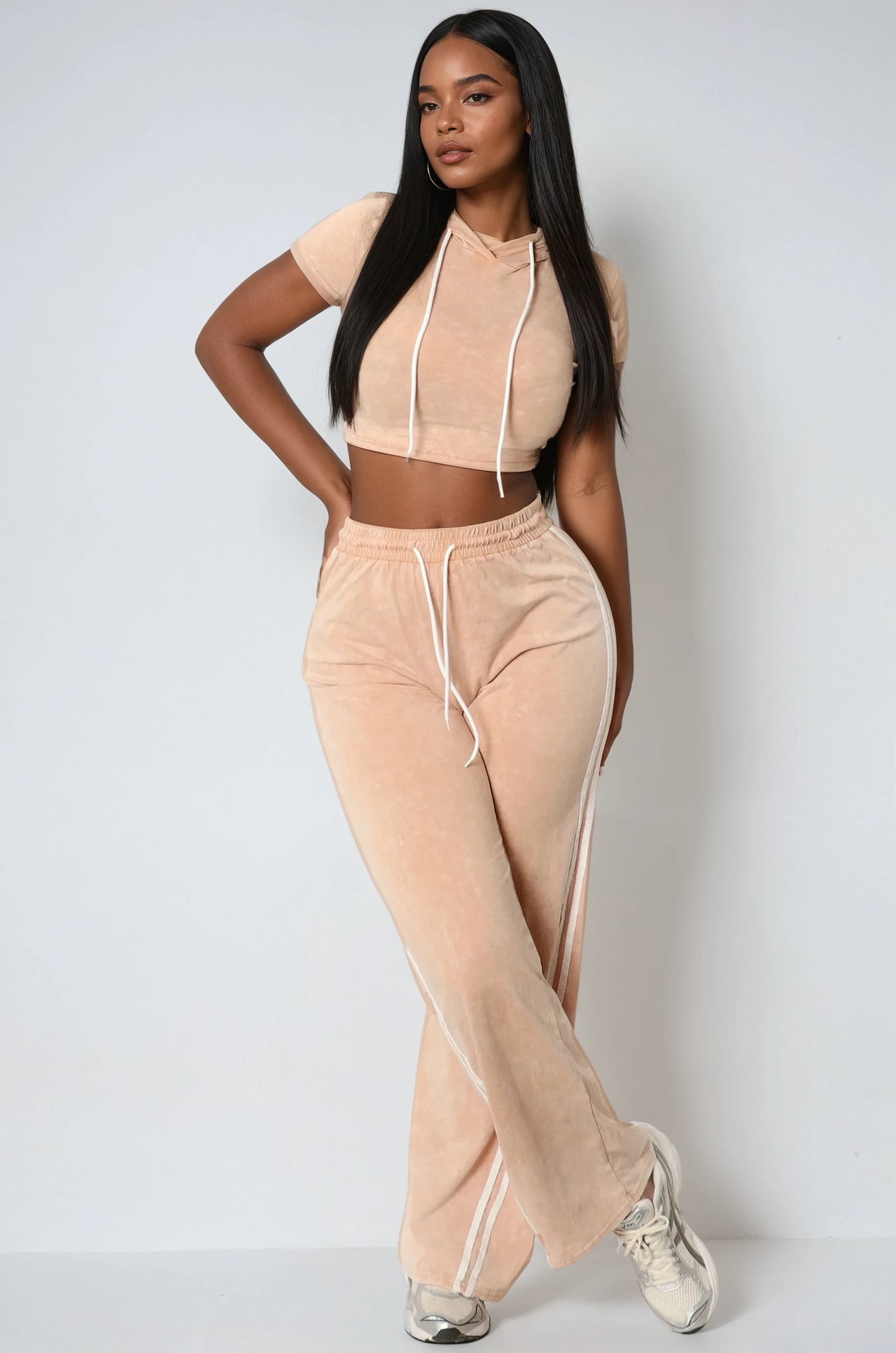 Two-piece cropped hoodie and jogger set in a mineral wash finish. Comfy fit with street-style edge for young women.