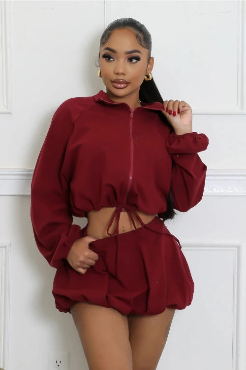 Chic burgundy windbreaker crop jacket and bubble skirt outfit, ideal for a day out with friends or everyday wear. Perfect outfit for teenagers or young women. Front view.