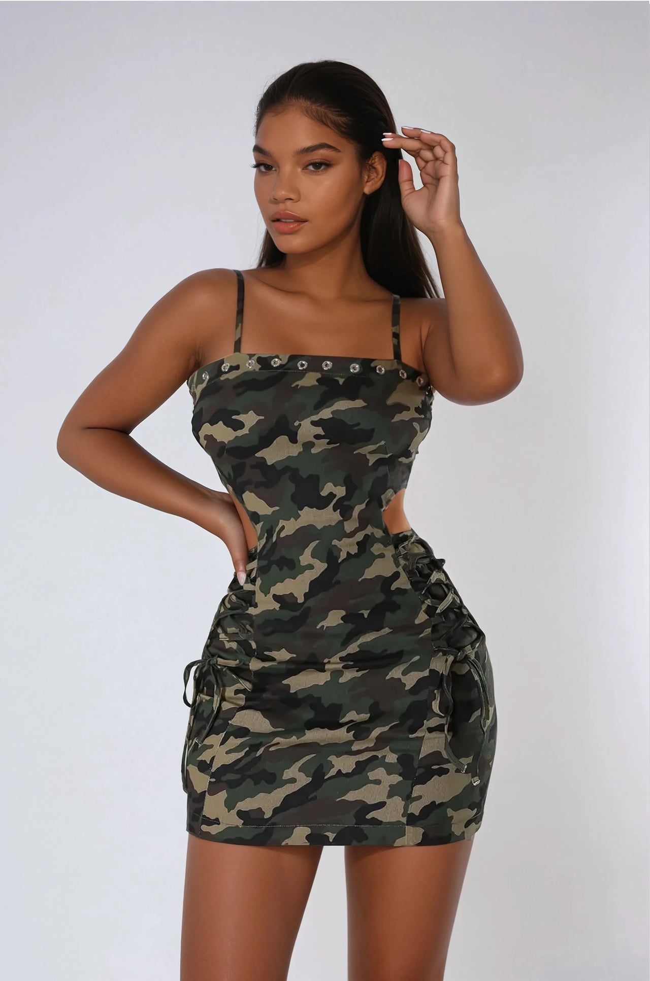 The Camo Crush Mini Dress stuns with a trendy camouflage print, side cutouts, and a flattering fit, making it a must-have for streetwear and night-out outfits.