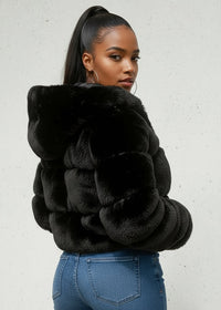 Thumbnail for Woman wearing a black faux fur jacket against a light background