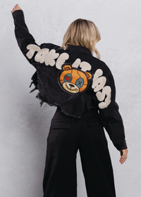 Thumbnail for Person wearing a black denim jacket with a teddy bear graphic and text on the back against a white background
