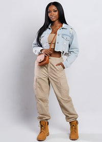 Thumbnail for Woman wearing a Pink seal light blue denim jacket, beige pants, and brown boots on a white background