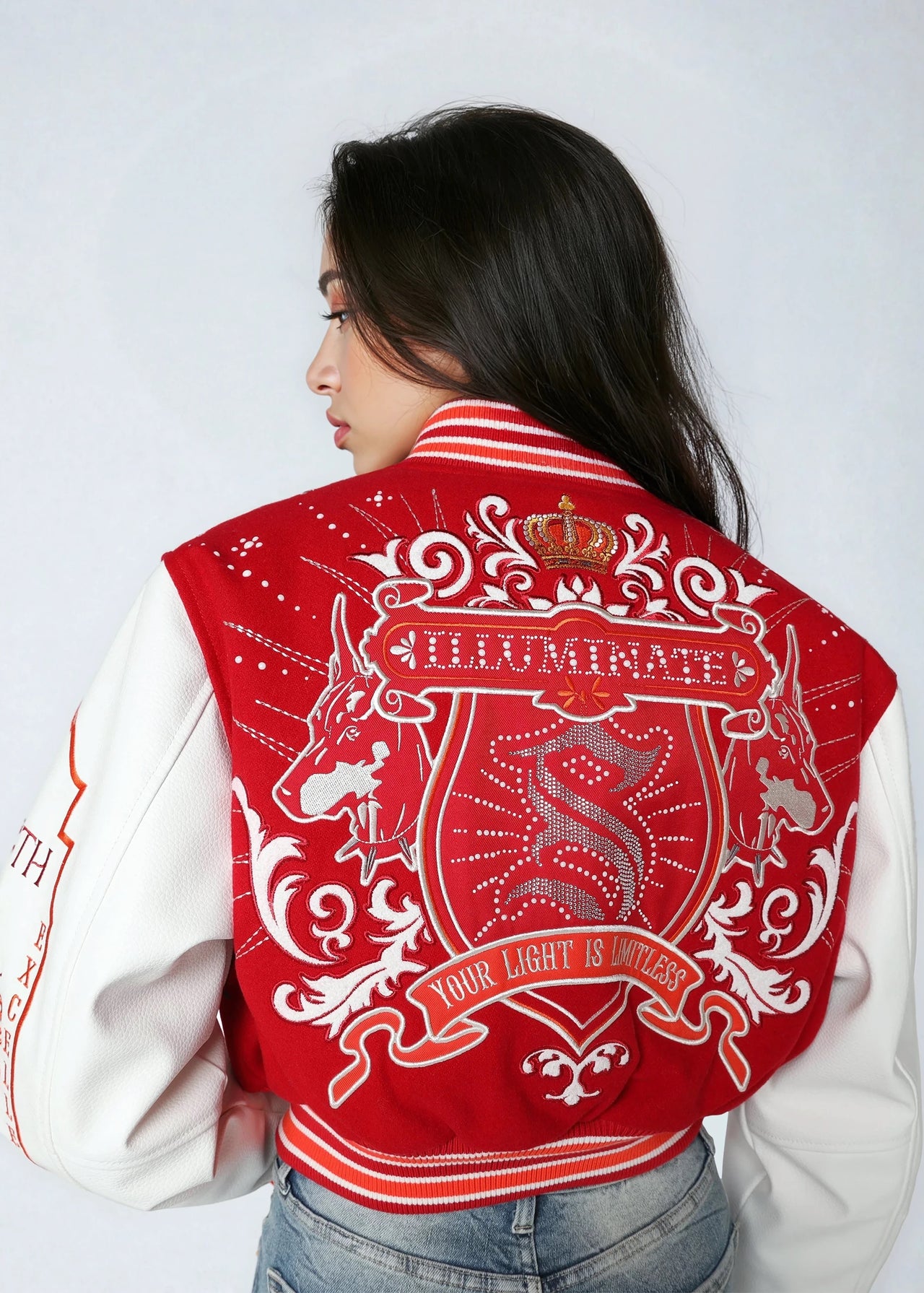 Cropped varsity jacket with empowering embroidery and bold streetwear style.