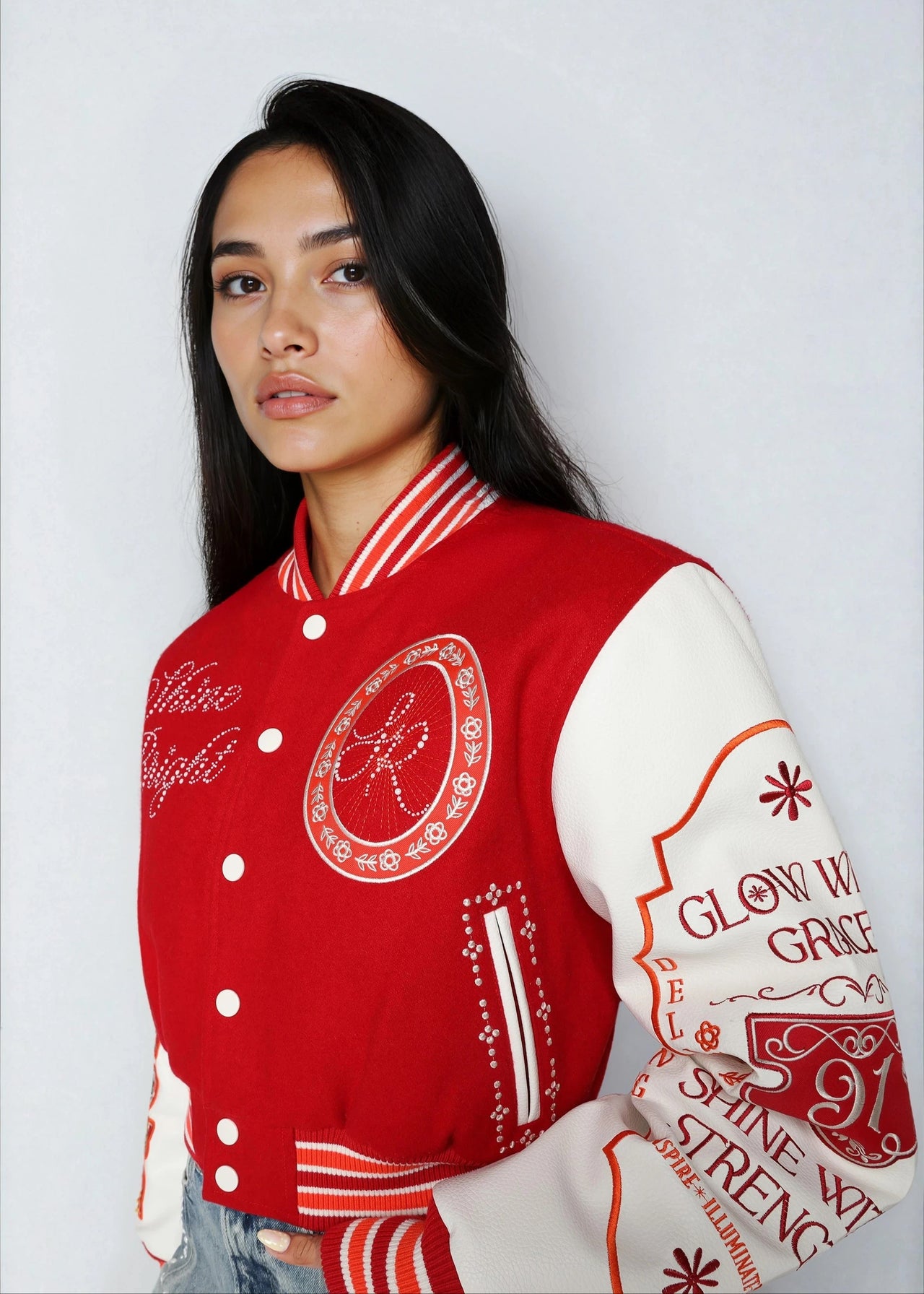 Cropped varsity jacket with empowering embroidery and bold streetwear style.