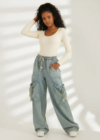 Thumbnail for Woman wearing a white long-sleeve top and Pink Seal light blue cargo pants on a white background