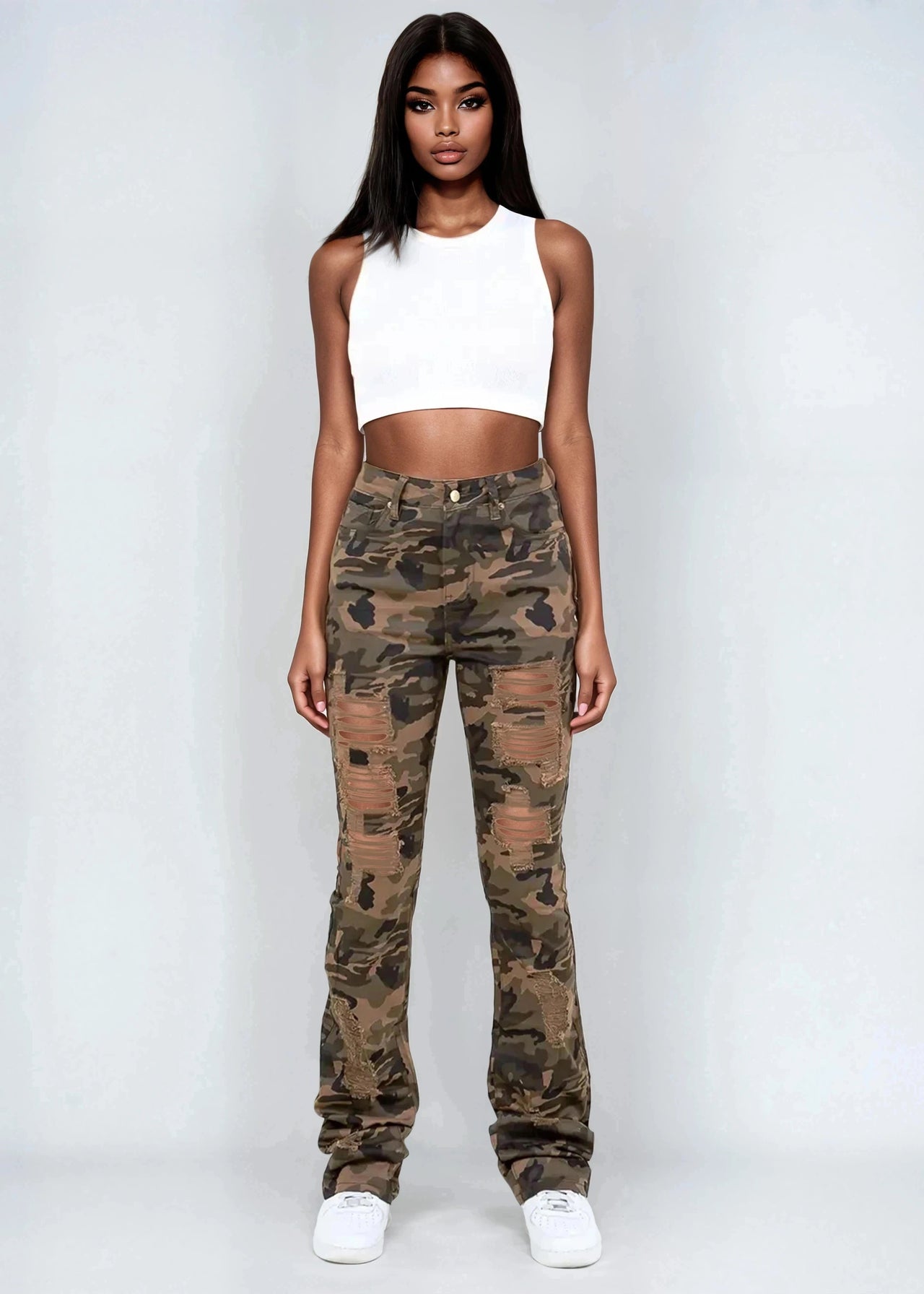 Woman wearing a white crop top and camouflage pants on a plain background