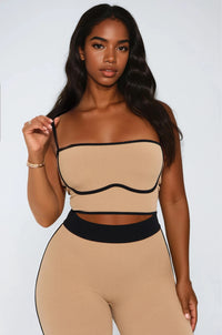 Thumbnail for Woman wearing a beige and black outfit against a white background