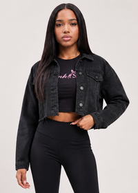 Thumbnail for A woman modeling a black denim jacket, black cropped tank top with a pink 