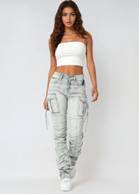 Thumbnail for Woman wearing light blue stacked jeans and a white top on a white background