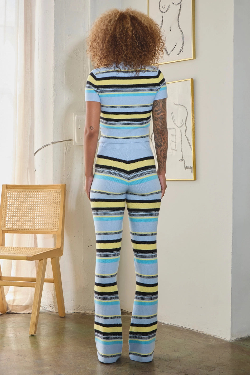 women wearing striped knit crop top with wide-leg pants in bold multicolor hues.