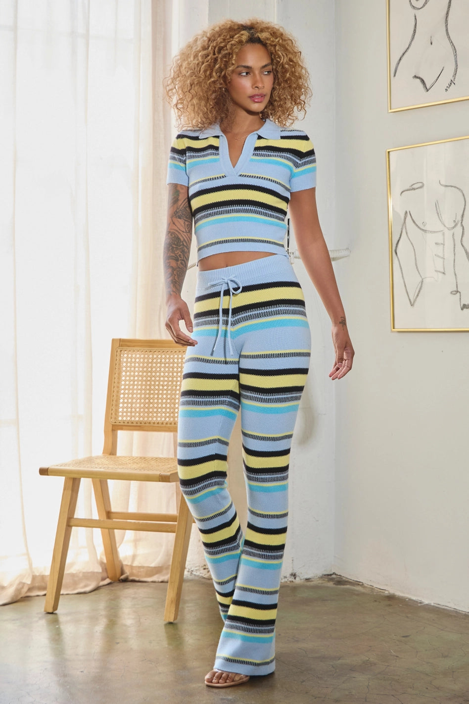 women wearing striped knit crop top with wide-leg pants in bold multicolor hues.