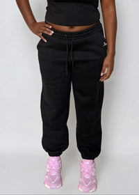 Thumbnail for Woman wearing a black crop top and black sweatpants with 'Pink Seal' logo on a white background