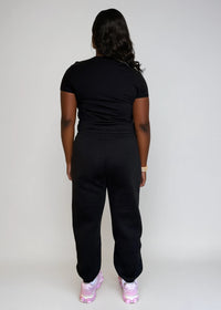 Thumbnail for Person wearing a black outfit with pink shoes on a plain background