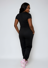 Thumbnail for Woman wearing a black outfit with pink shoes on a white background