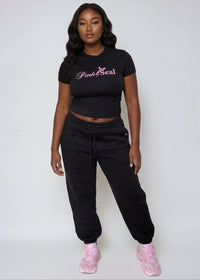 Thumbnail for Woman wearing a Pink Seal branded black outfit with pink shoes on a white background