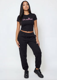 Thumbnail for Woman wearing a black crop top with 'Pink Seal' branding. 