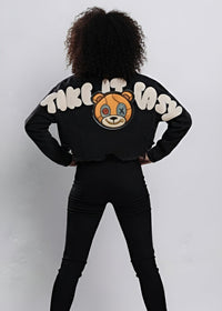 Thumbnail for Pink Seal black cropped denim jacket with a bear graphic and 'Take It Easy' text on the back against a white background