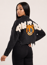 Thumbnail for A woman modeling a black denim jacket from the back, featuring a large teddy graphic and patch on the back.