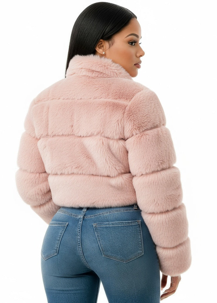 Person wearing a pink fur jacket and blue jeans on a white background