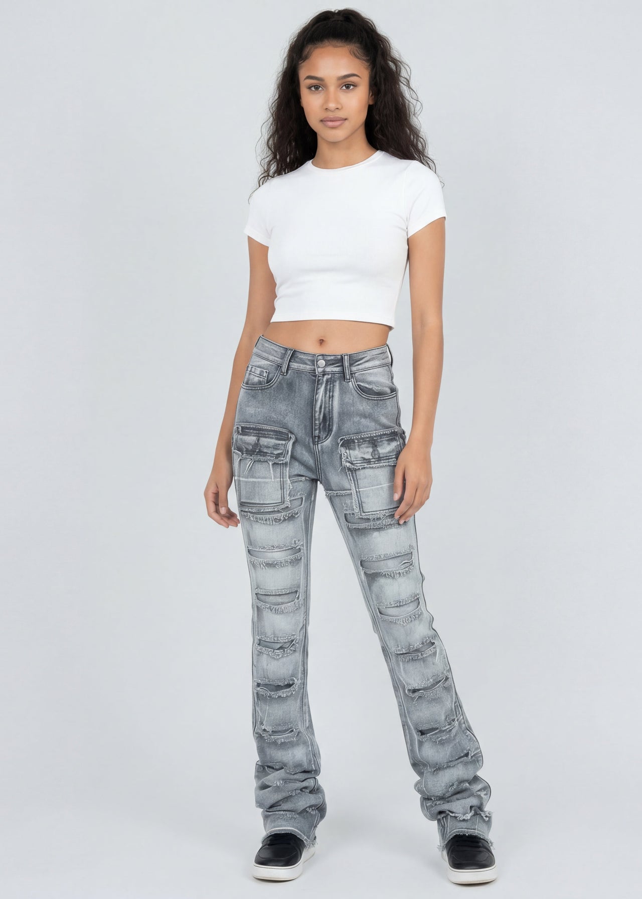 Woman wearing light grey jeans and a white top on a white background