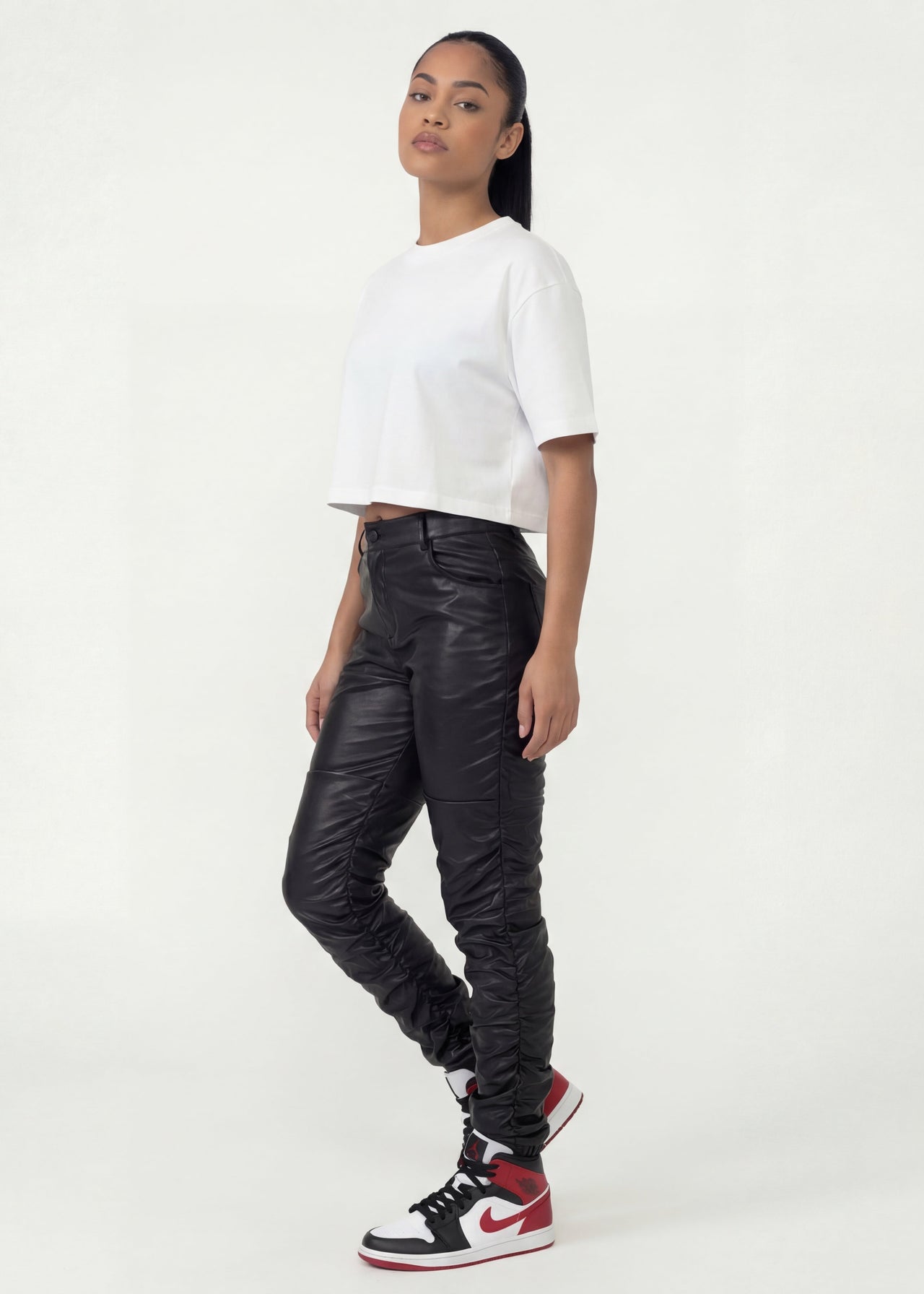 Pink Seal High-rise thick PU leather pants with ruched detailing.