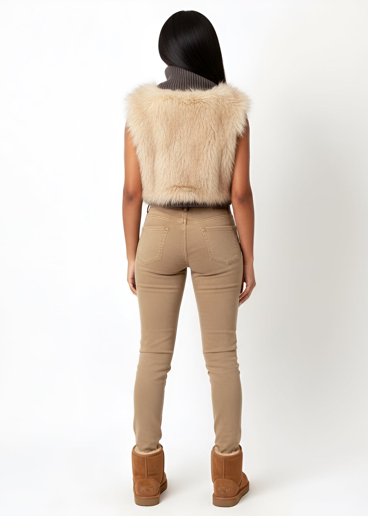 Person wearing a Cropped faux fur vest with shawl collar and ribbed knit base.